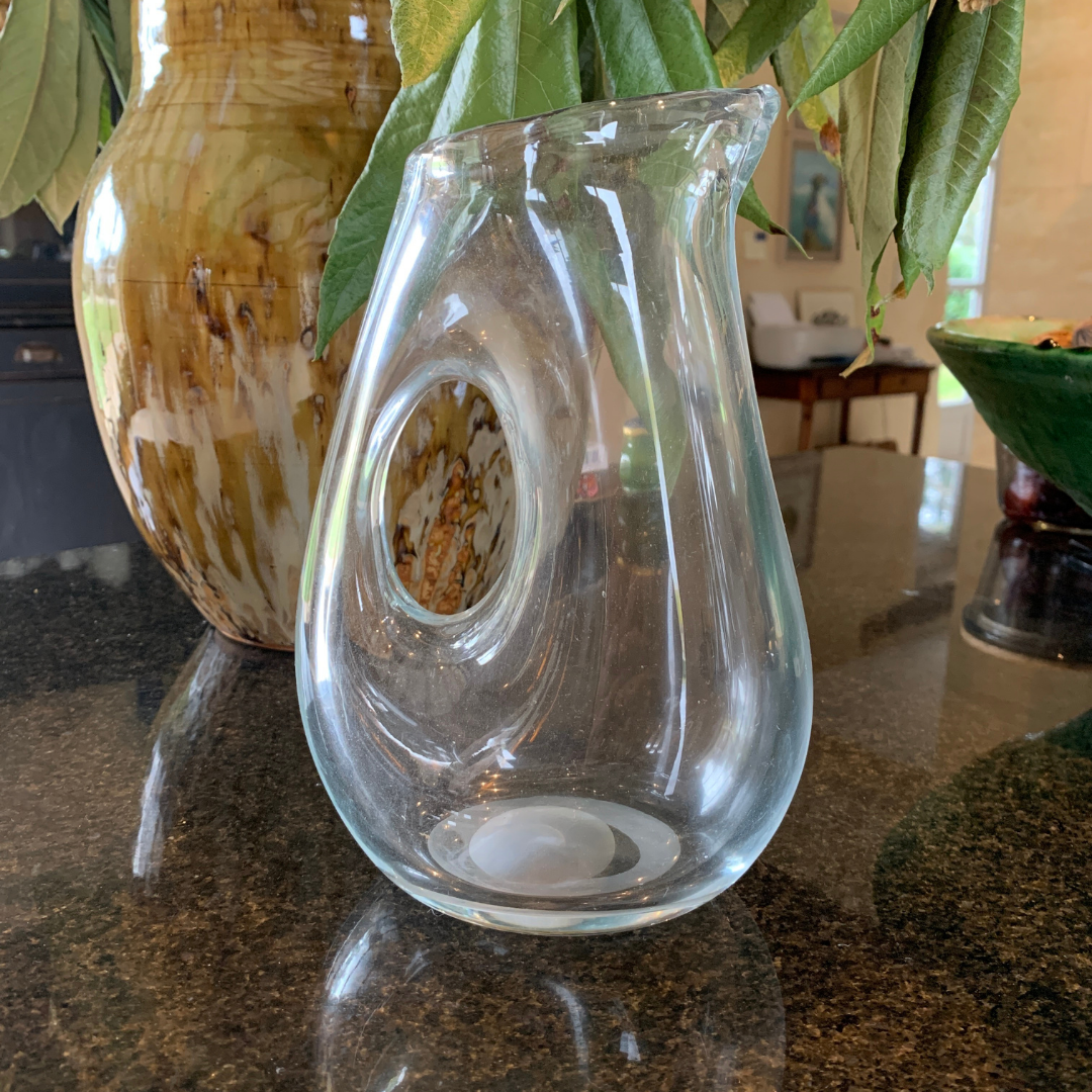 Carafe en verre avec une une anse en forme de trou.